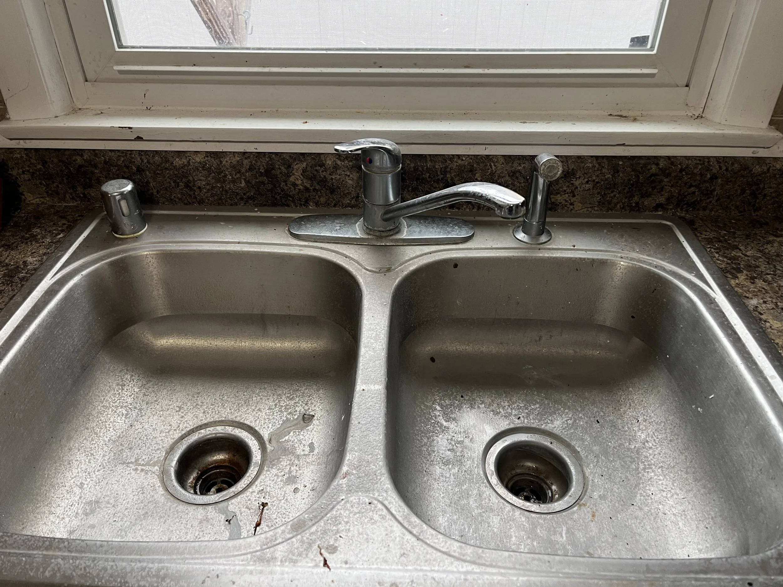 Dirty kitchen sink before cleaning during a residential cleaning service