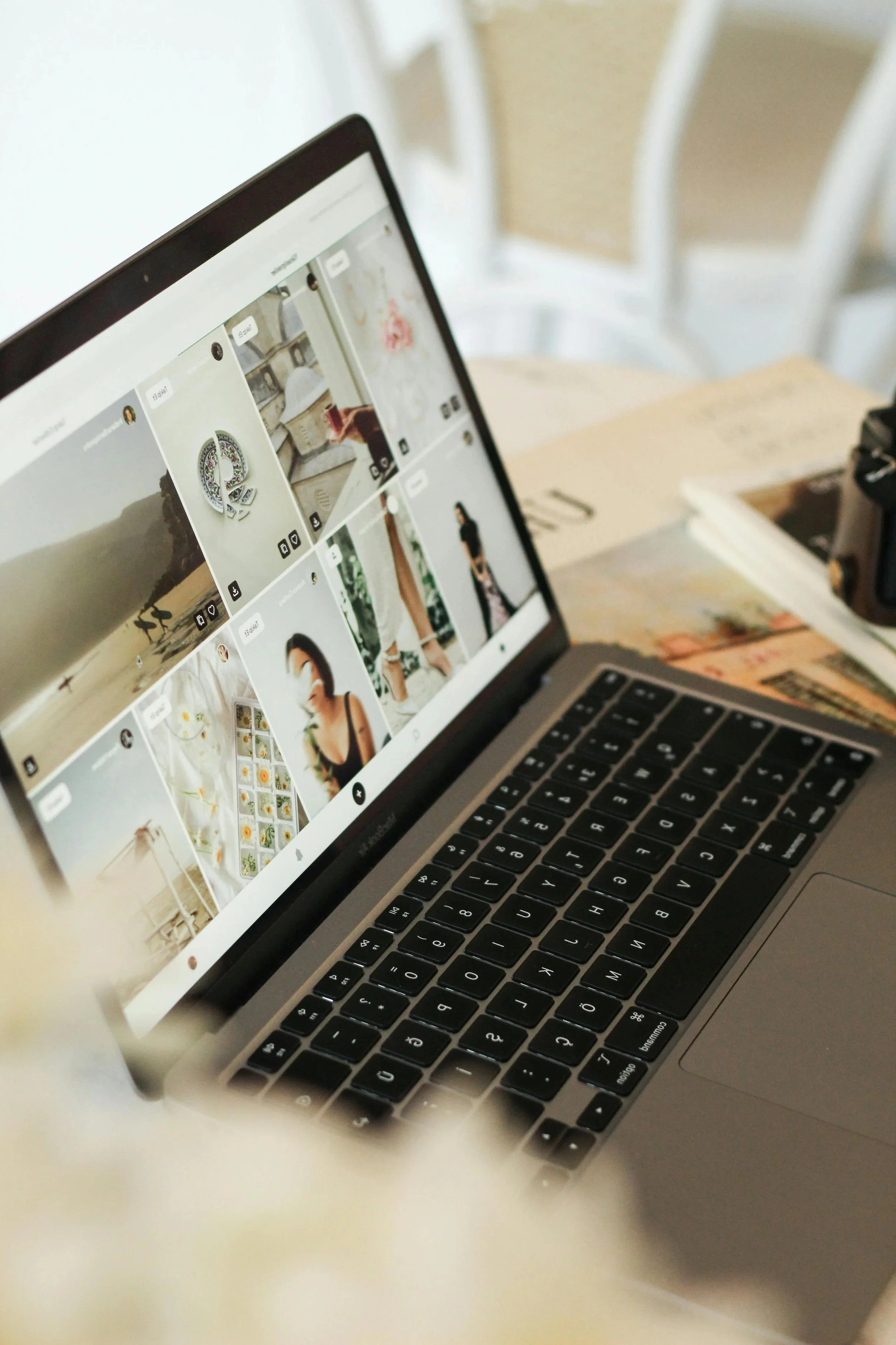 Laptop on white table displaying a social media profile with photos of home decor and interior design.