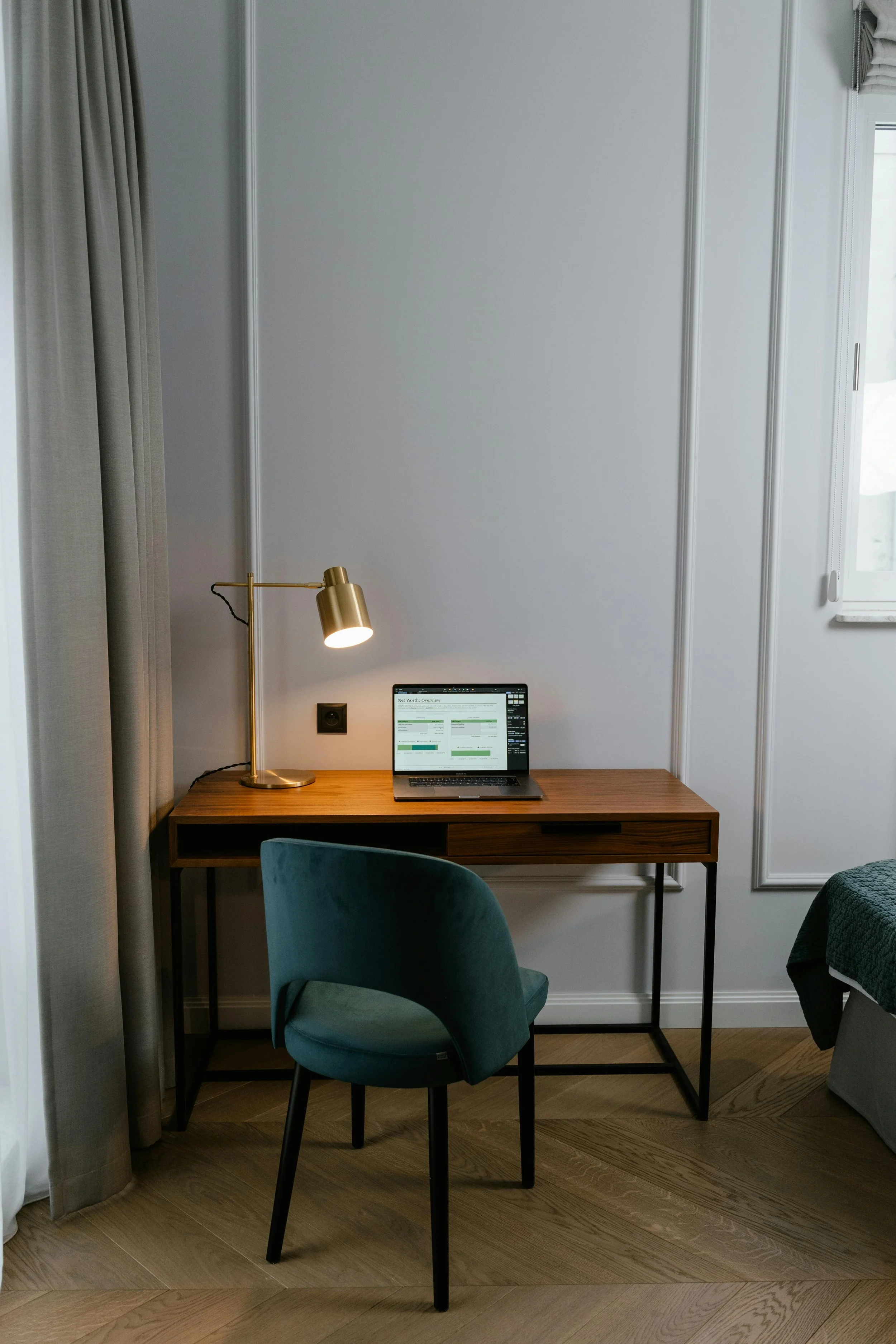 Workspace with a minimalist desk, open laptop, and fancy lamp.