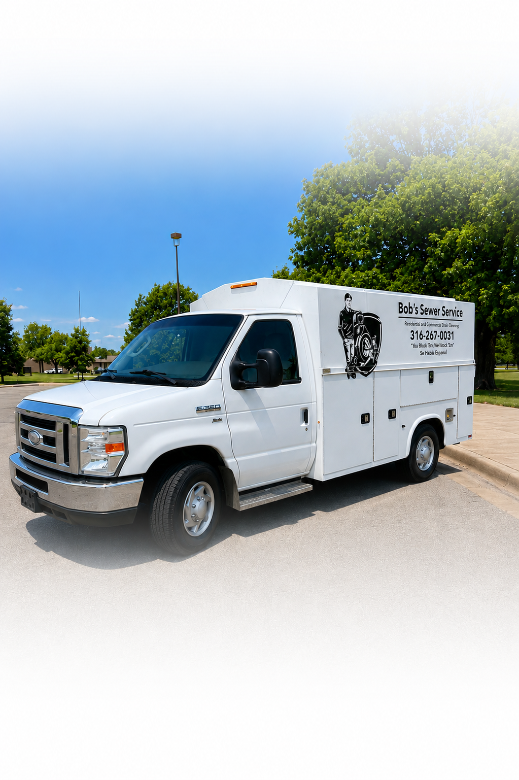 White service truck for Bob's Sewer Service parked on a street, with trees and a park in the background.