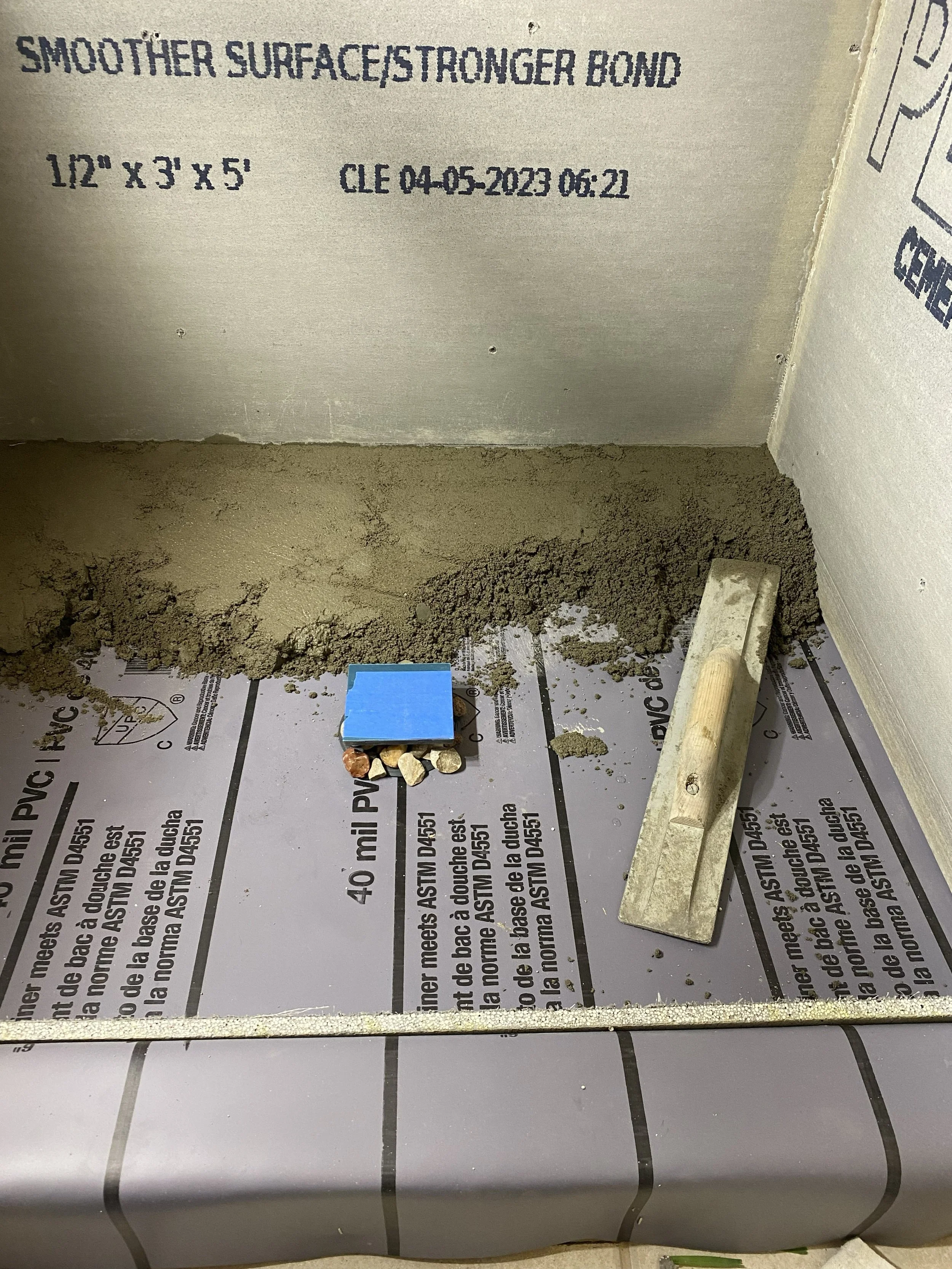 Showe pan liner with pebbles to keep weep holes free of debris