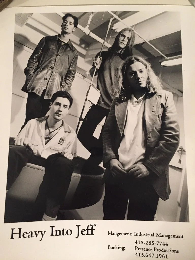 Black and white photo of four people in a room with pipes and lighting, with text reading "Heavy Into Jeff," and contact information for industrial management and presence productions.