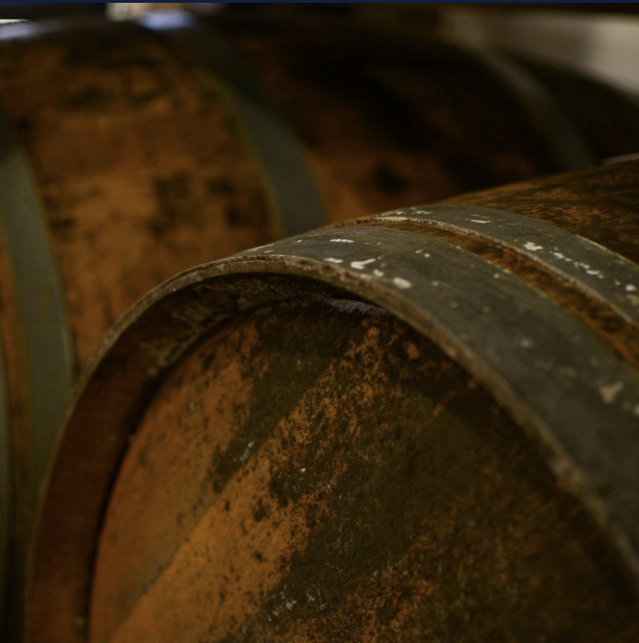 Close-up of rusty, weathered metal barrels stacked together.