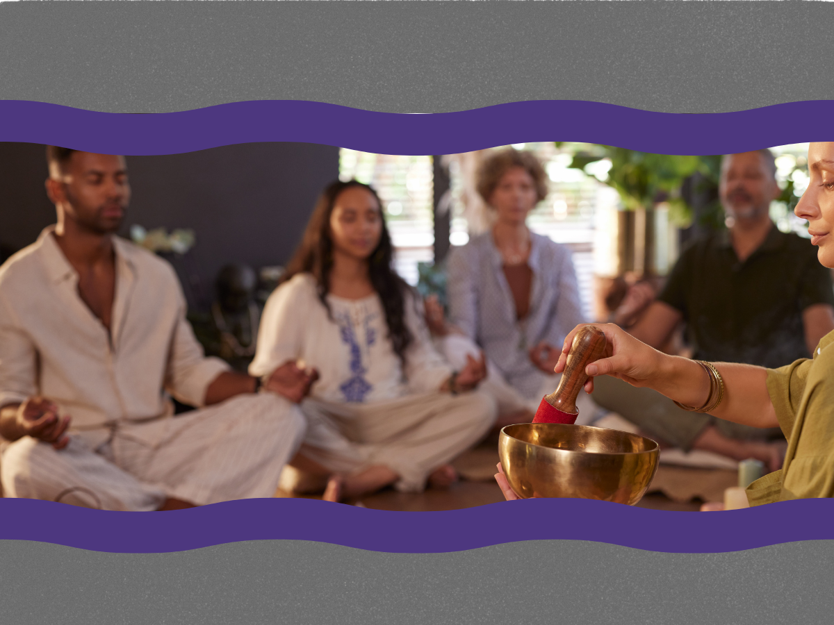 Group of people sitting on the floor participating in a meditation or spiritual session, with a woman using a singing bowl.