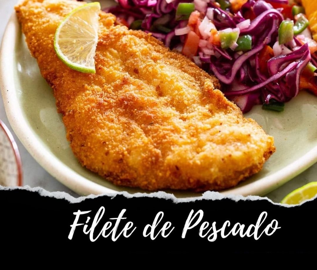 Breaded fish fillet with a lemon wedge on top, served with a side of purple cabbage slaw with diced green and orange vegetables.