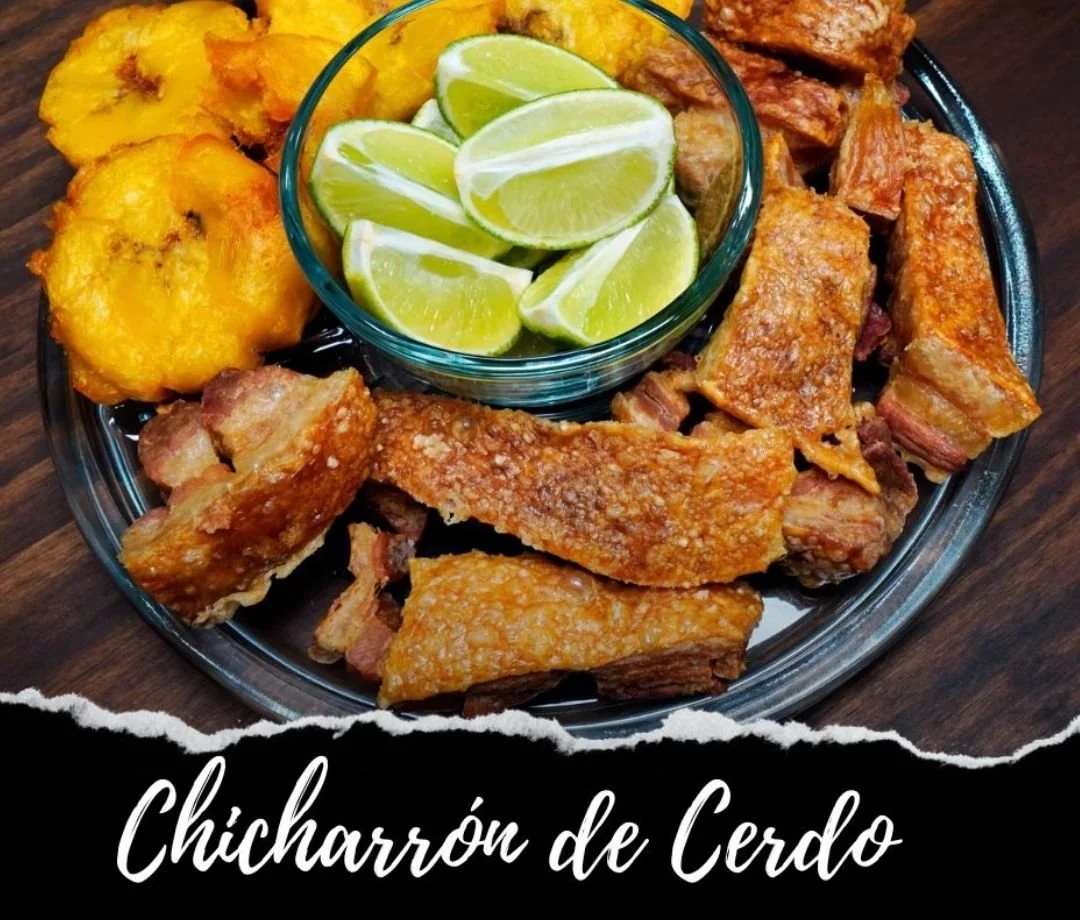 Plate of fried pork cracklings with fried plantains and lime wedges.