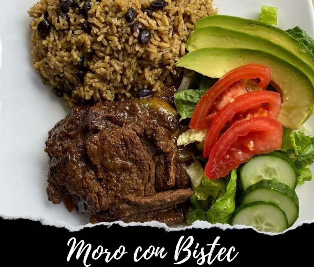 Plate of rice and beans, braised beef, and a side salad with sliced tomatoes, cucumbers, and avocado.