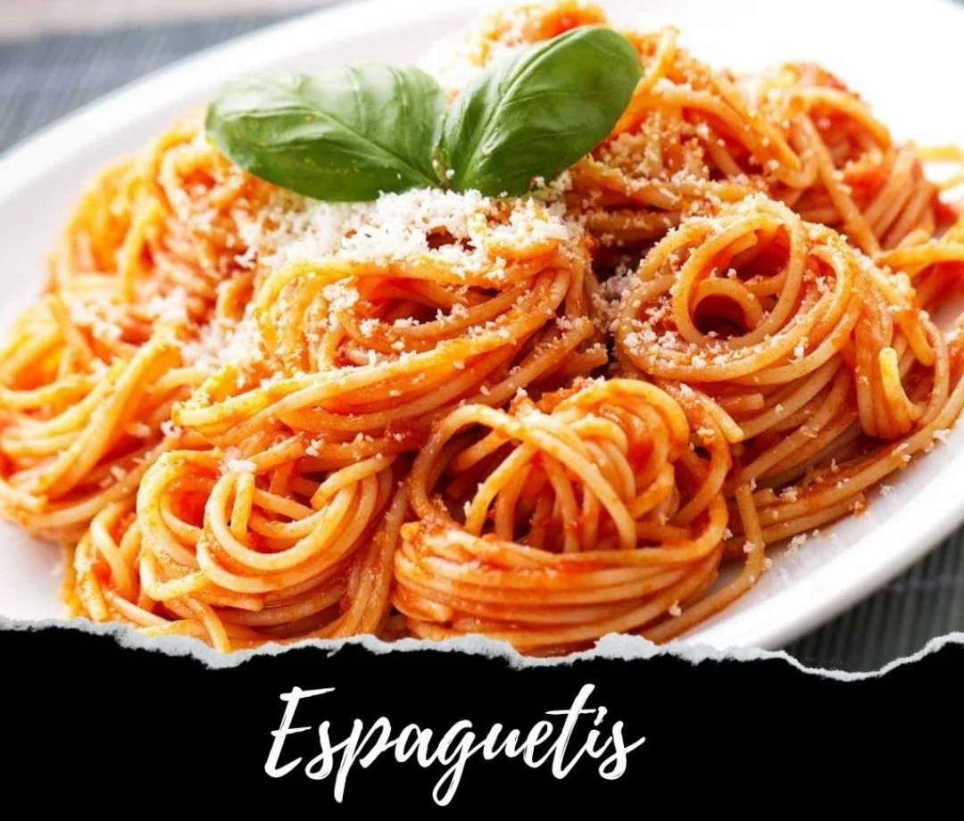 A plate of spaghetti with tomato sauce topped with grated cheese and a basil leaf garnish.