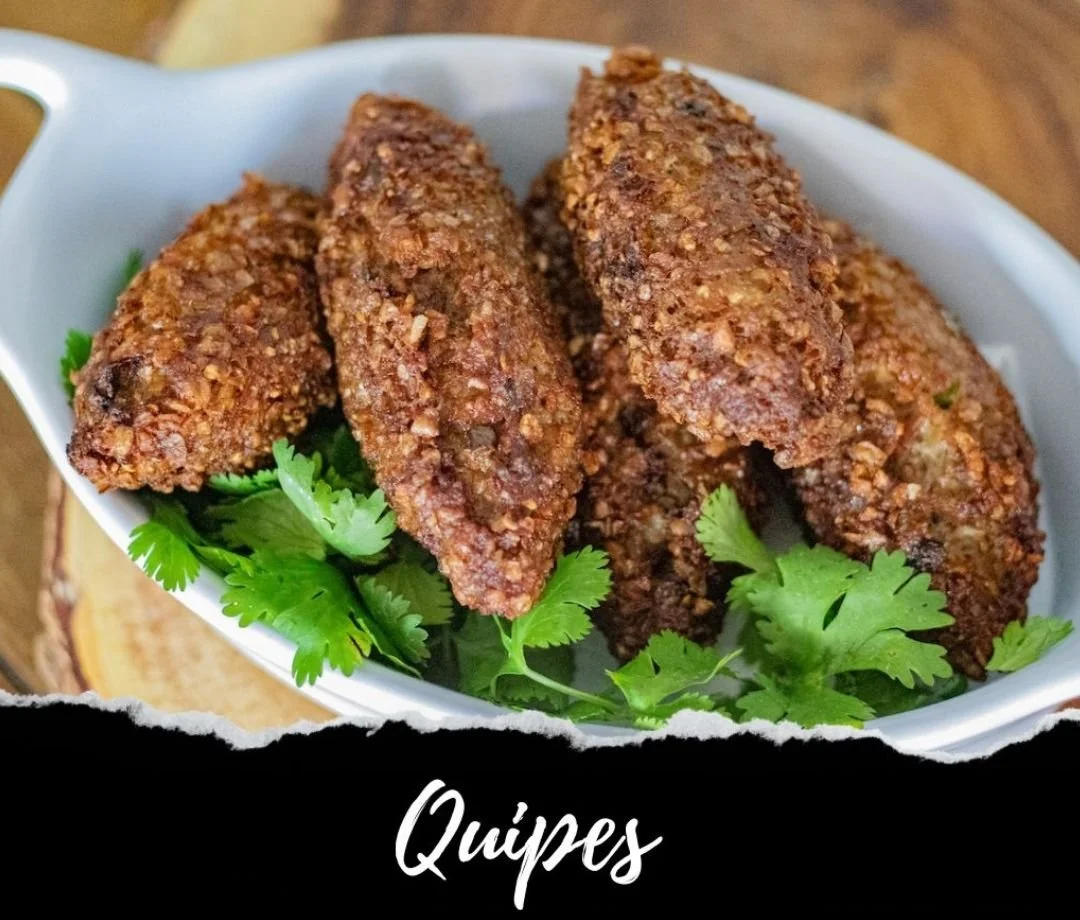 Fried quipes with a crispy exterior, garnished with fresh cilantro on a white dish.