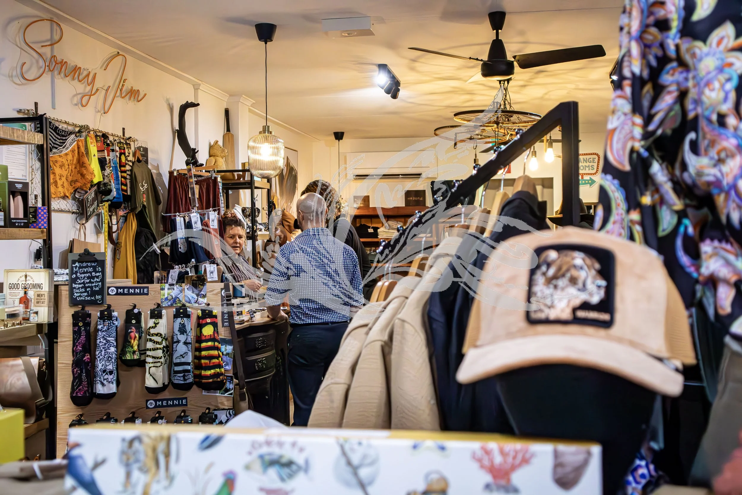 Inside a retail store with clothing racks, accessories, and shoes, where people are browsing and shopping.