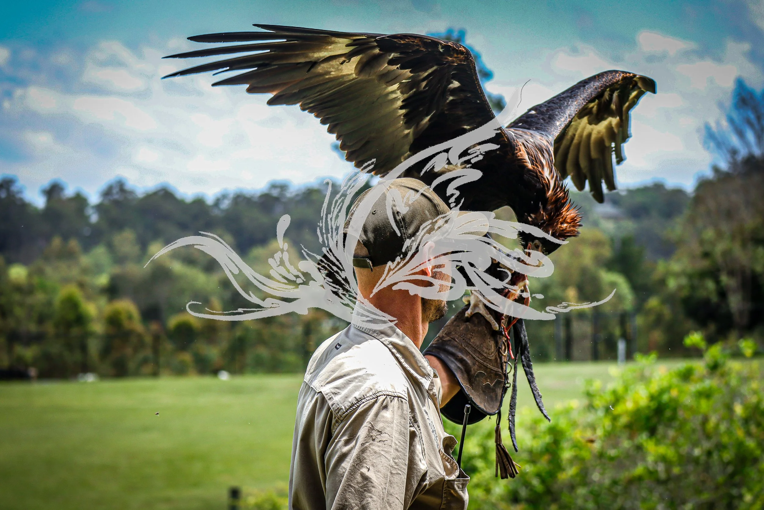 Two men are outdoors, one holding a large bird of prey on his arm. The man with the bird is wearing a beige jacket and the bird is perched on his leather glove. The background shows trees and a cloudy sky.