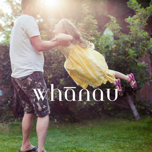 A man plays with a young girl in a garden with sunlight shining through trees, and the word 'whanau' overlaid.