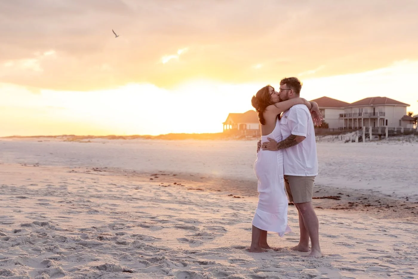 A bride and groom kissing during sunset on the beach in Gulf Shores Alabama photography by Kyle Rossi