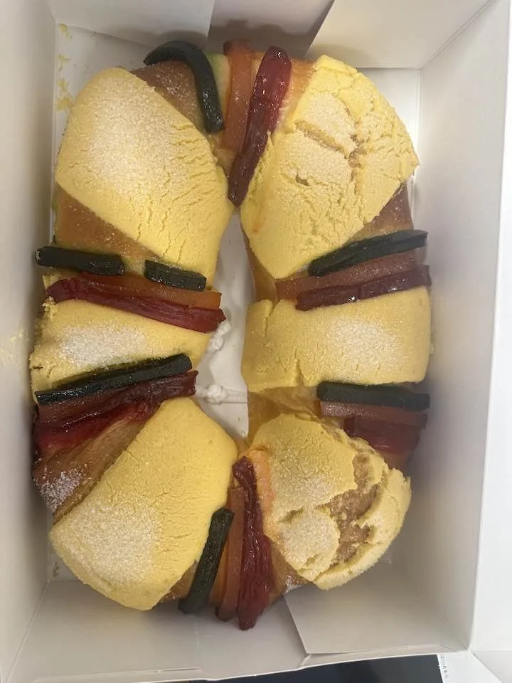 Box of four slices of cake topped with colorful gummy worms.