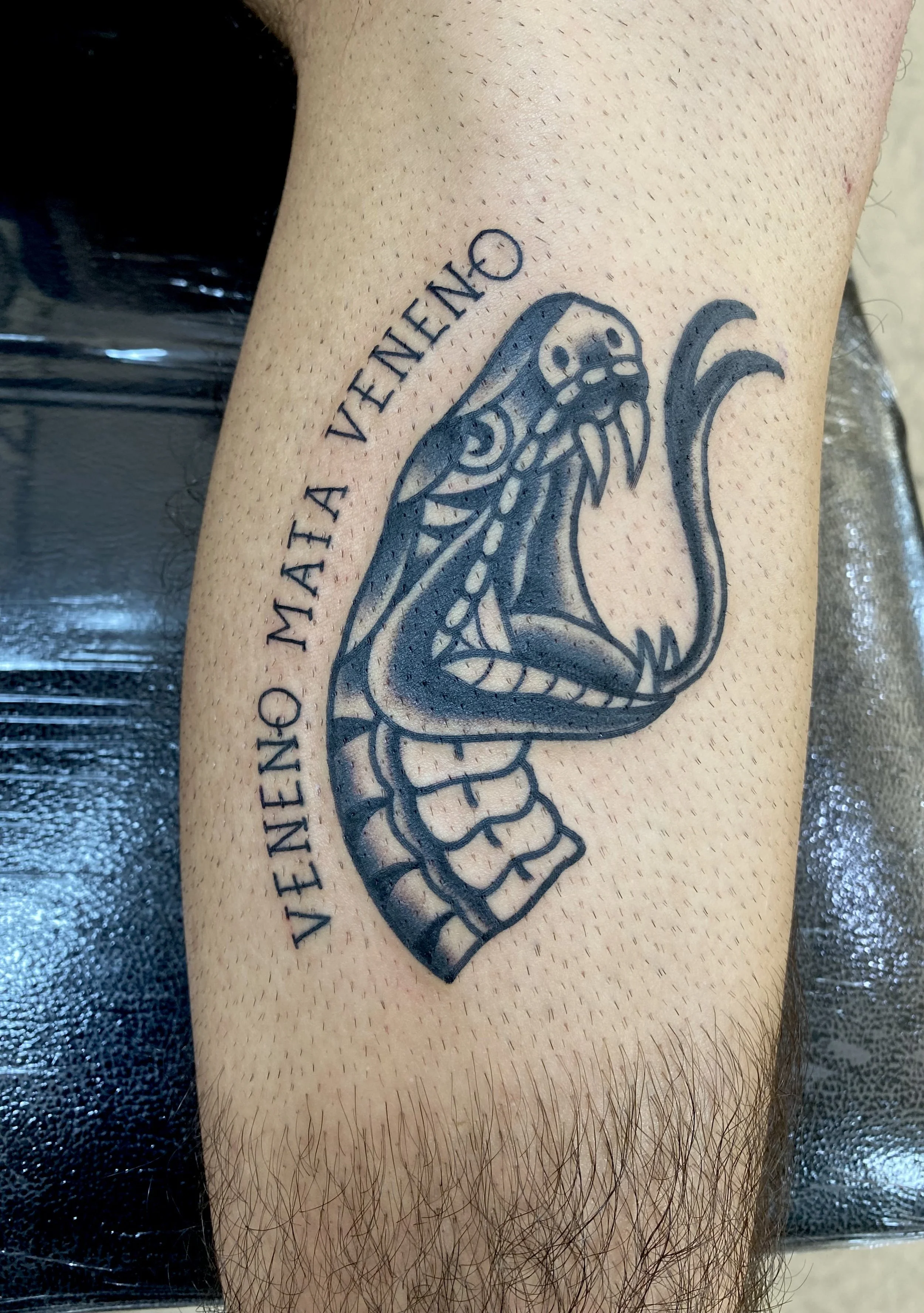 A tattoo of a clenched fist with intricate line work and shading, accompanied by text around it reading "VIENNA QUEEN."