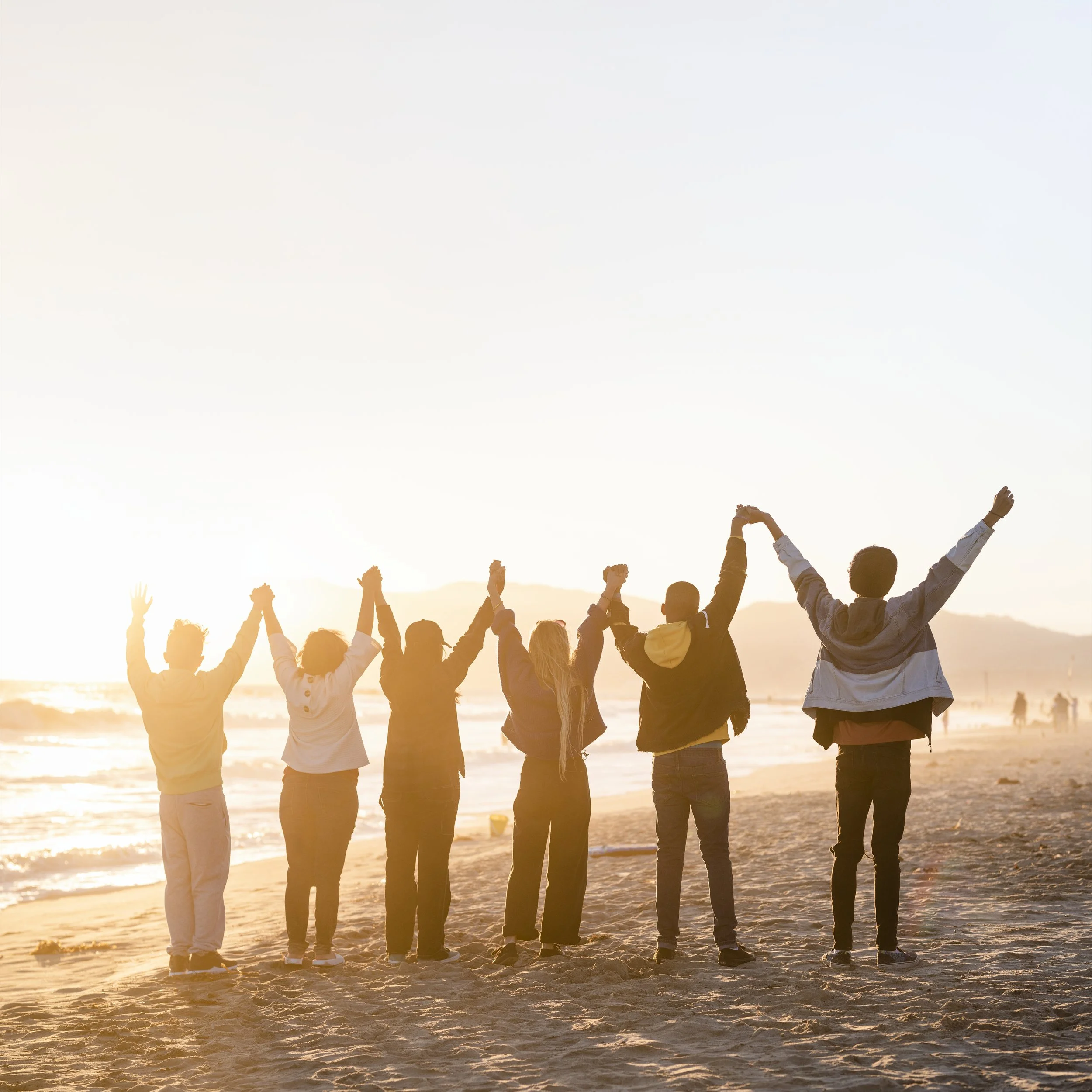 People holding hands with sun rays