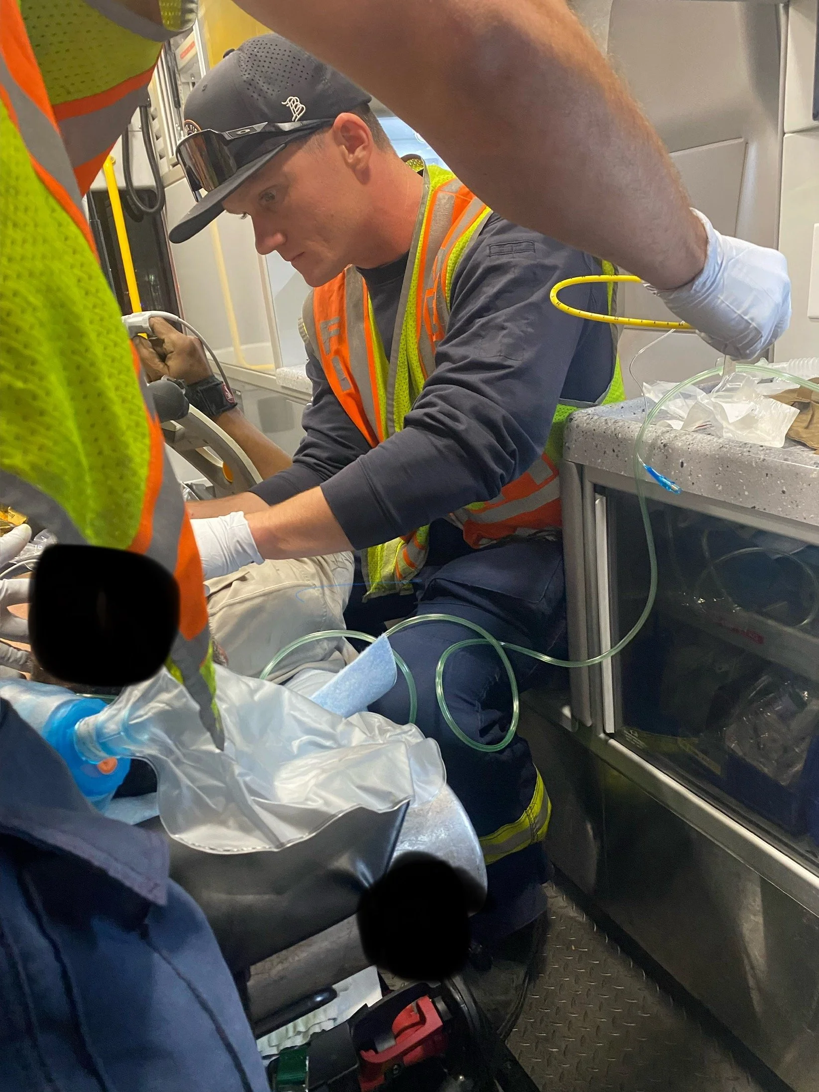 Emergency medical personnel providing urgent care to a patient in an ambulance, with medical equipment and supplies nearby.
