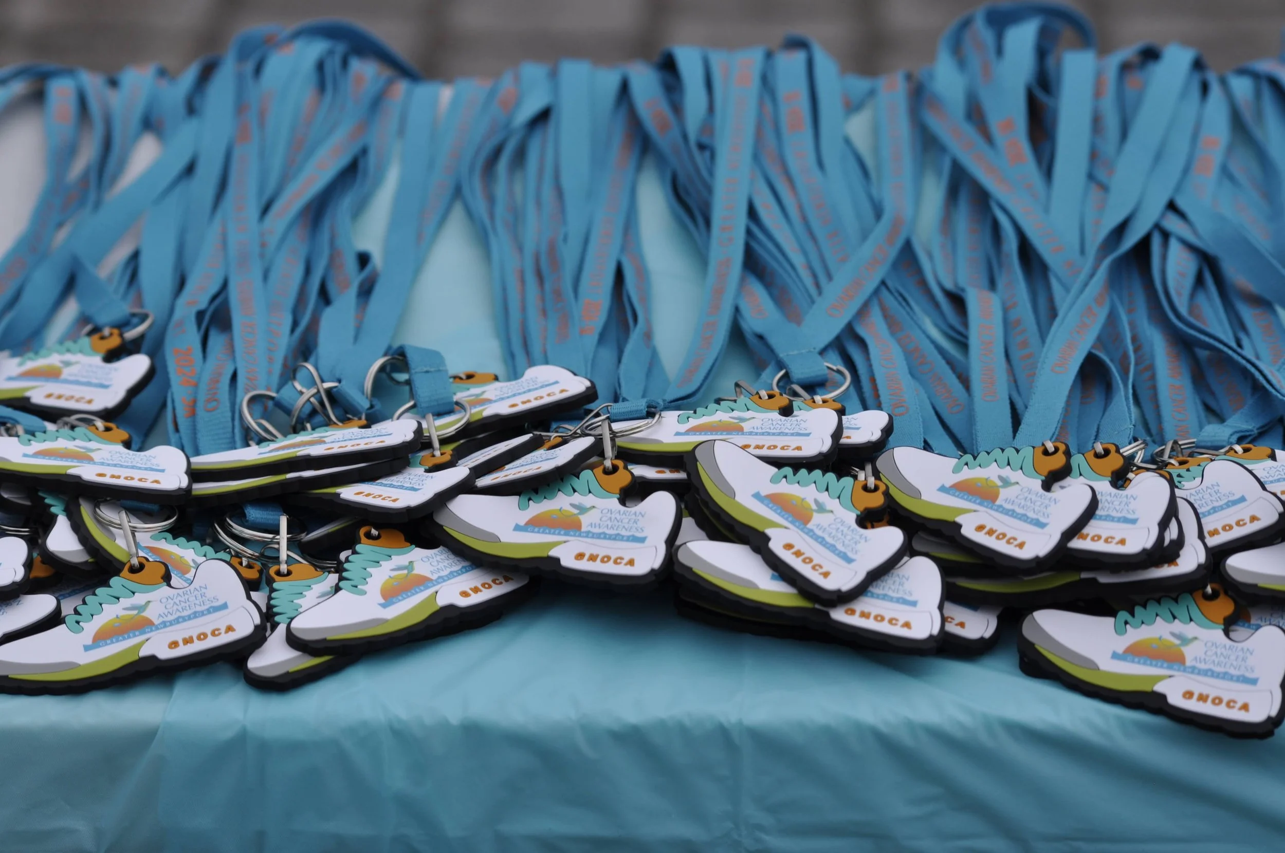 Medals and ribbons for ovarian cancer awareness event on a table.