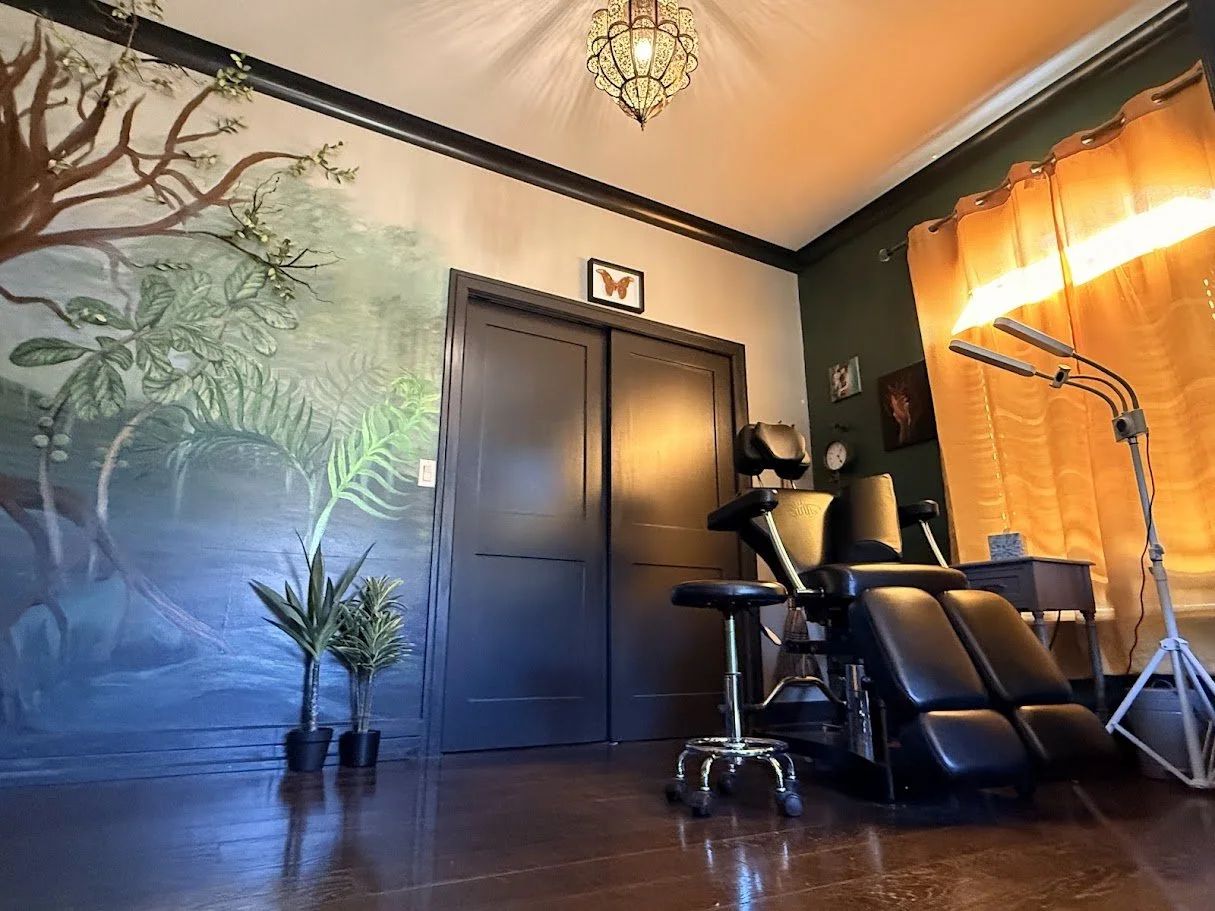 Inklinations private tattoo studio interior by Alicia Maye. Custom chair, hand-painted tropical mural wall, Cashmere WA.