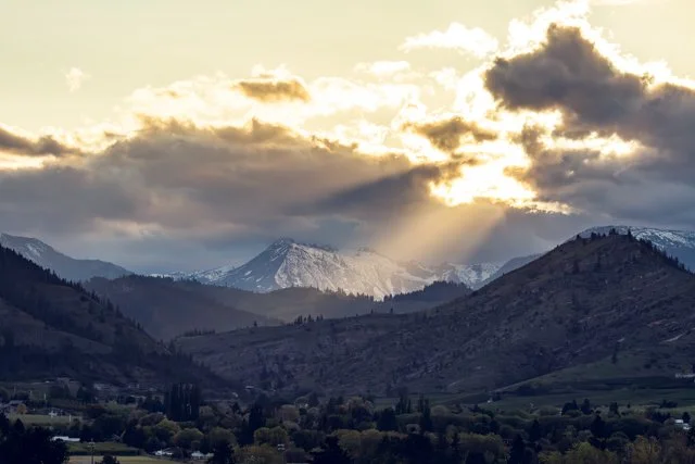 Cashmere Mountain landscape photography by Alicia Maye — god rays breaking through clouds over snow-capped Cascade peaks | Cashmere Washington | fine art print | Alicia Maye Art