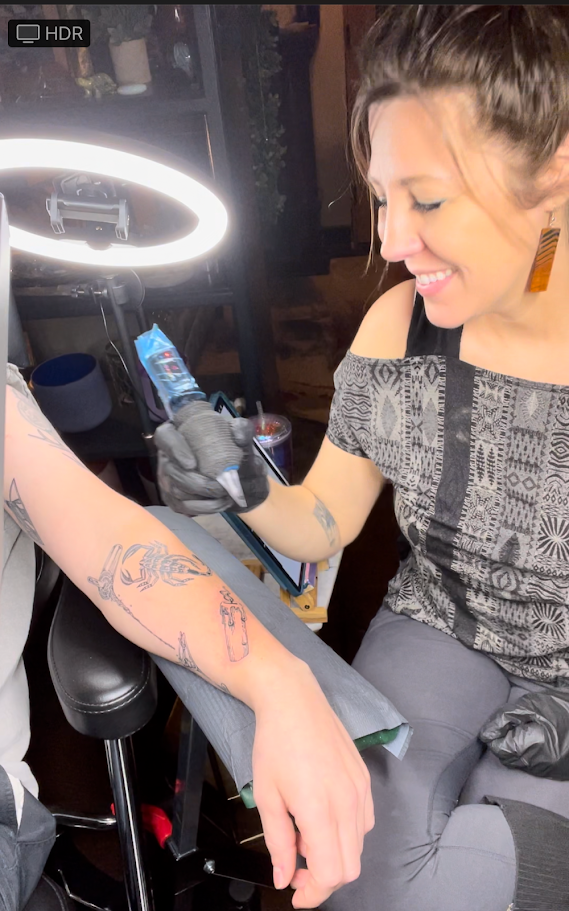 Alicia Maye tattooing a client at Inklinations. Ring light, focused work, private studio Cashmere WA.