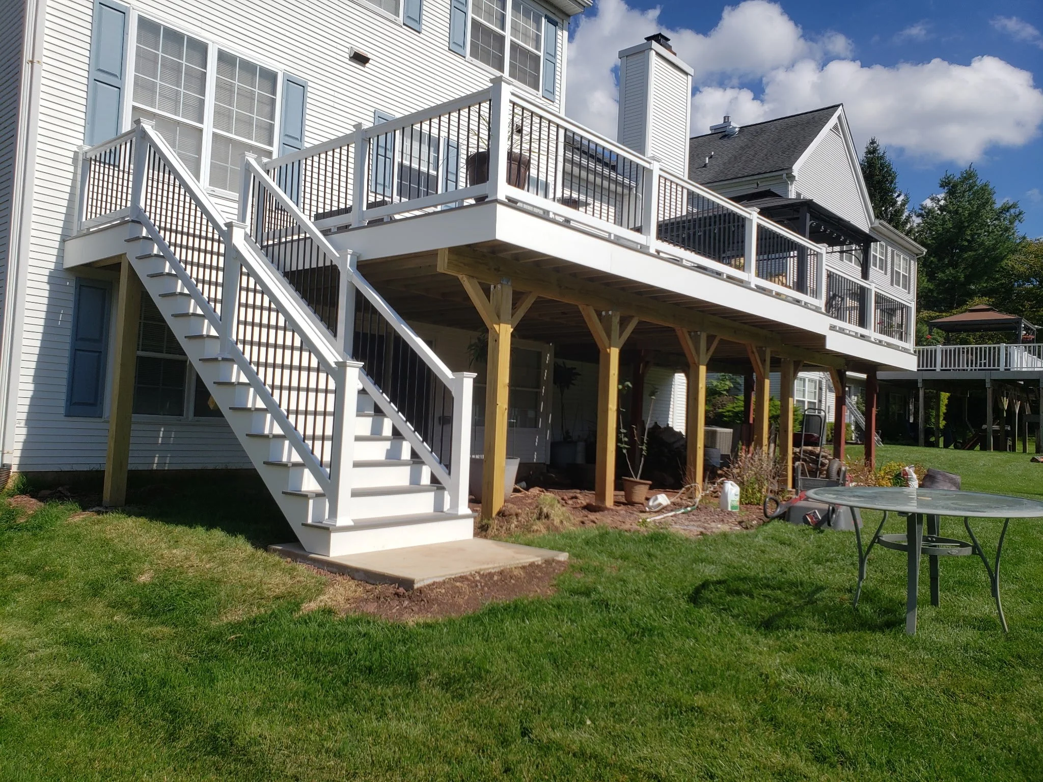 Deck with white Trex Select railings and Fiberon composite decking with white PVC fascia running all across