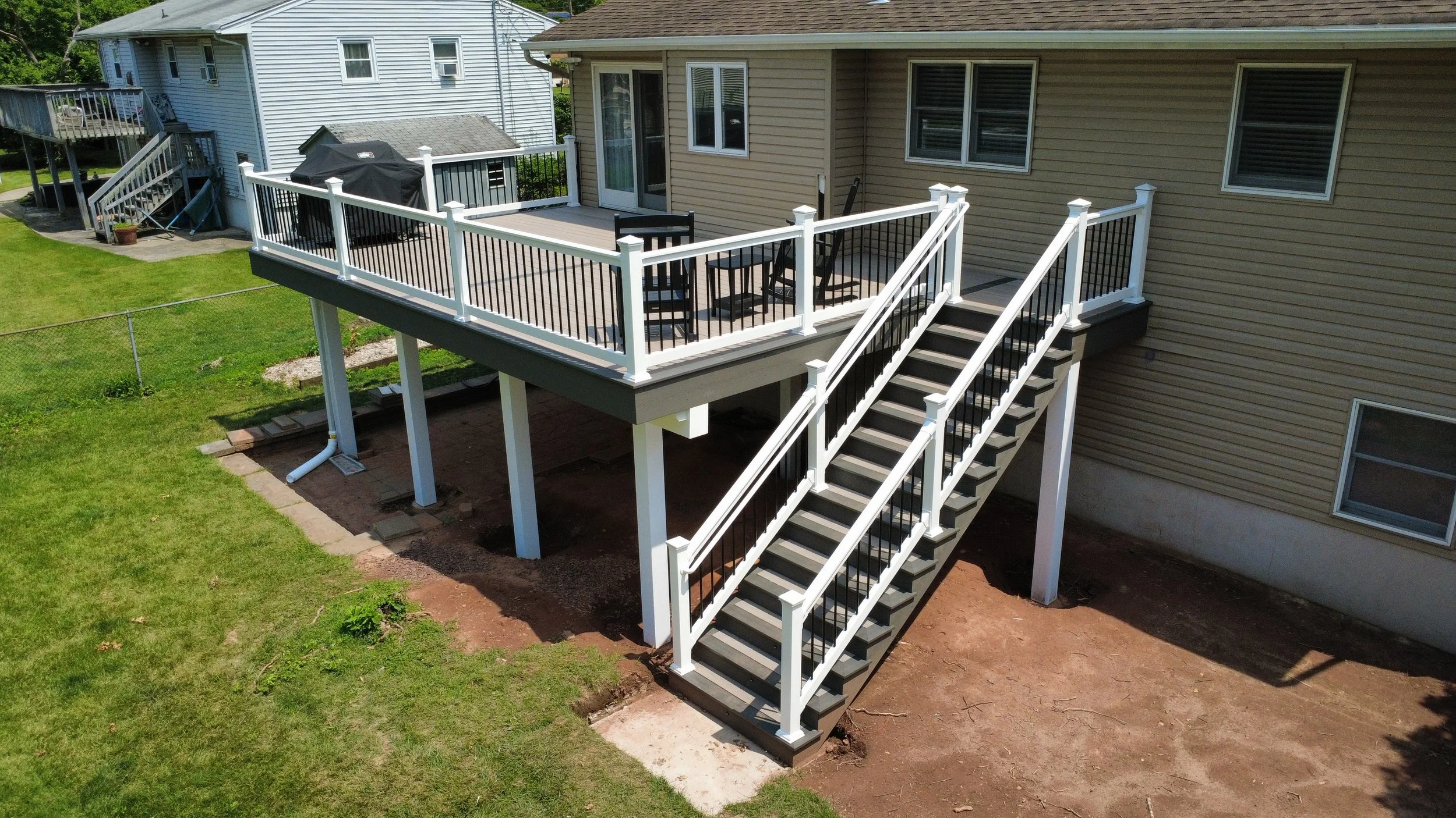 (After shot) Finished Deck with Vinyl Railing with Black Aluminum Balusters, Fiberon Sanctuary Earl Grey picture frame with Fiberon Good Life Cabana decking.