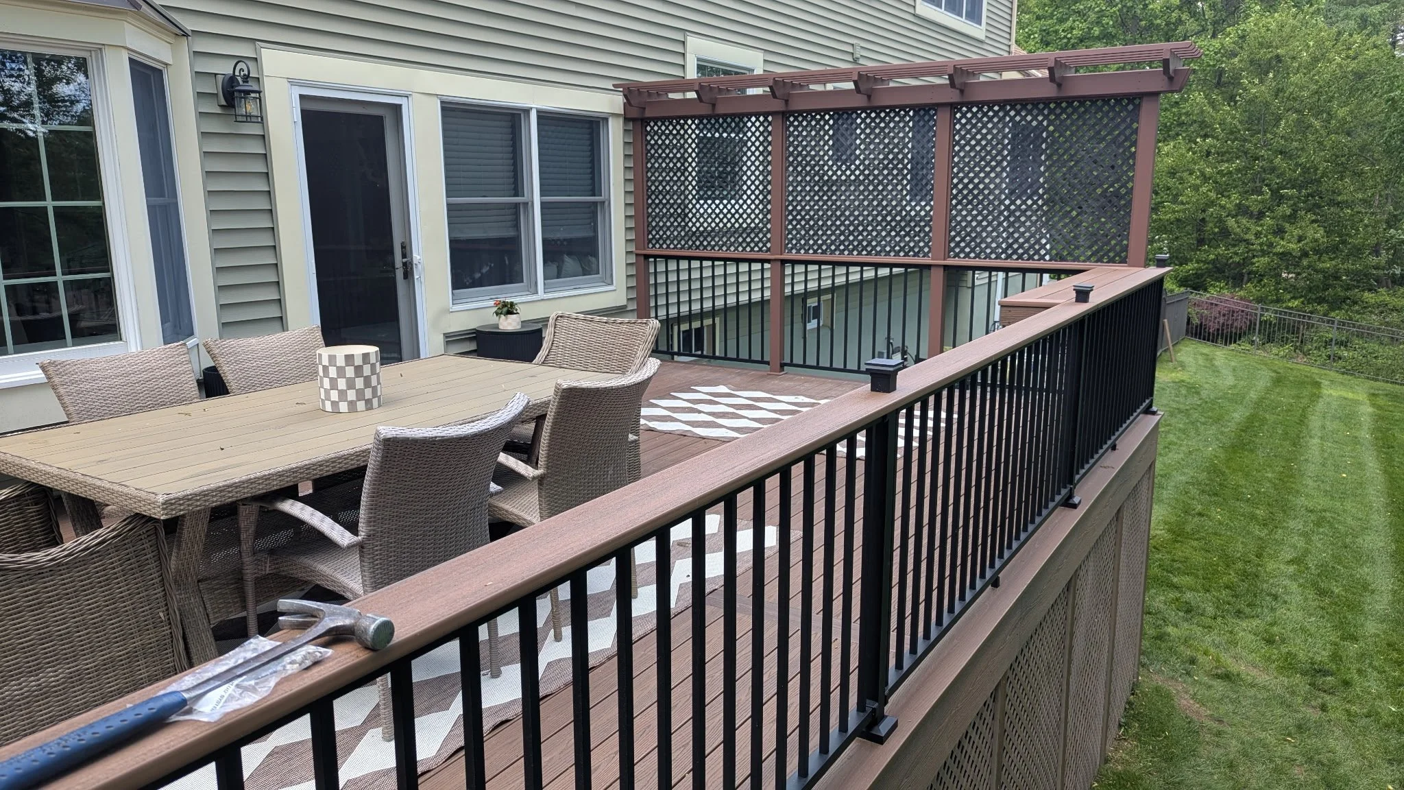 Same Fiberon Sanctuary deck showcasing Westbury railing caps with the drink rail decking. Custom built privacy rail in the background