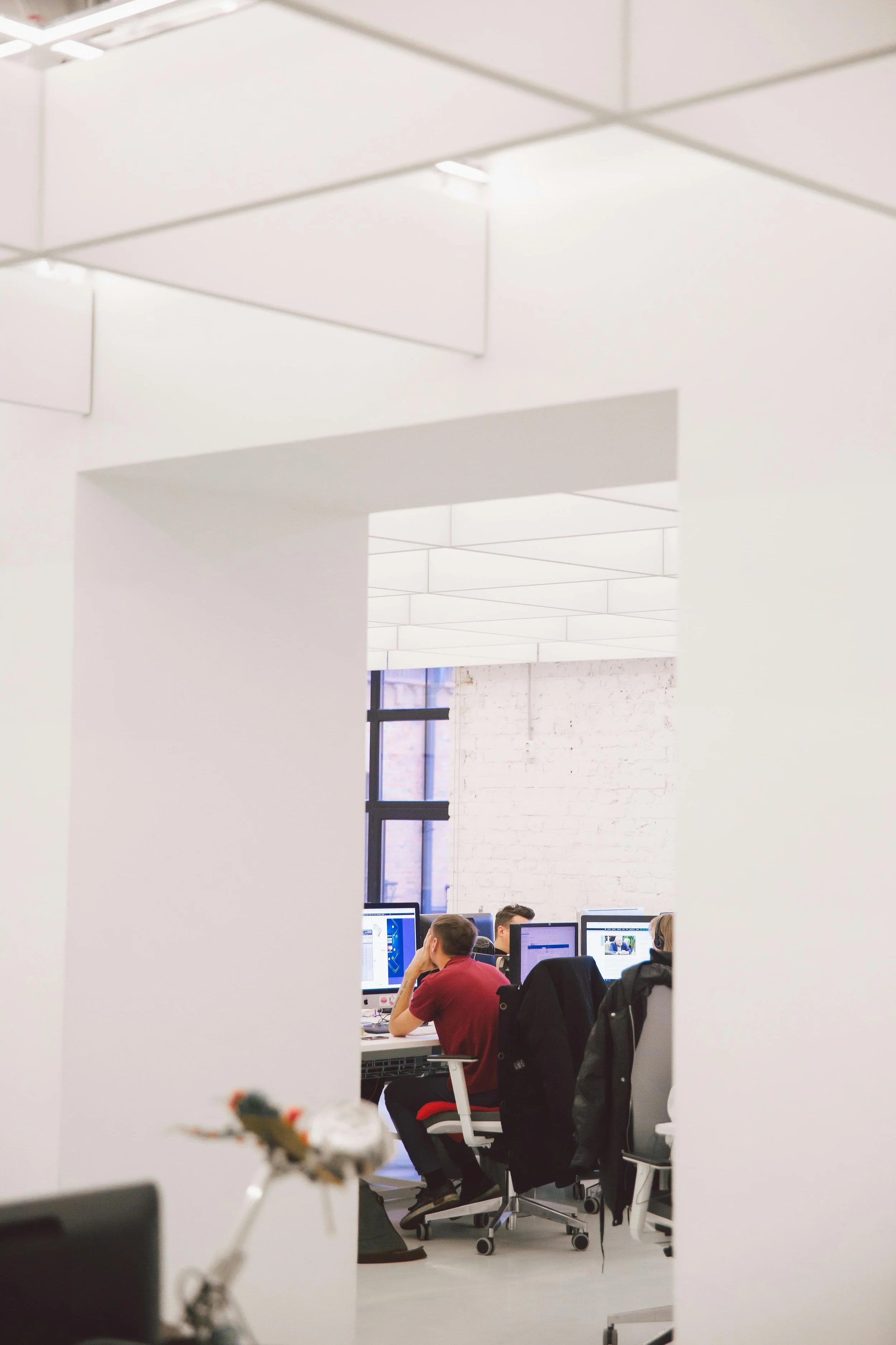 People working at computer desks in a modern shared office.