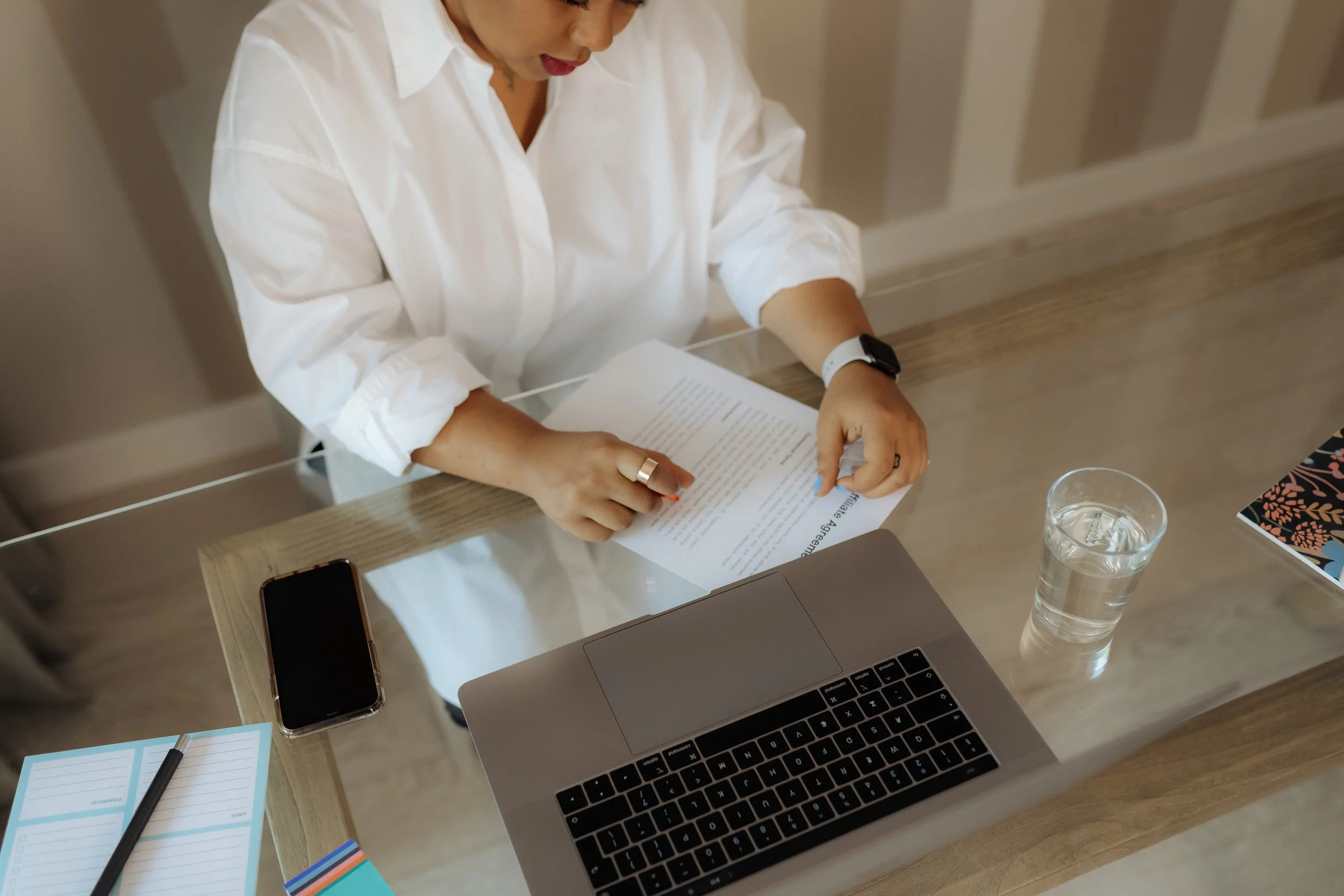 A professional reviewing a document at their desk.
