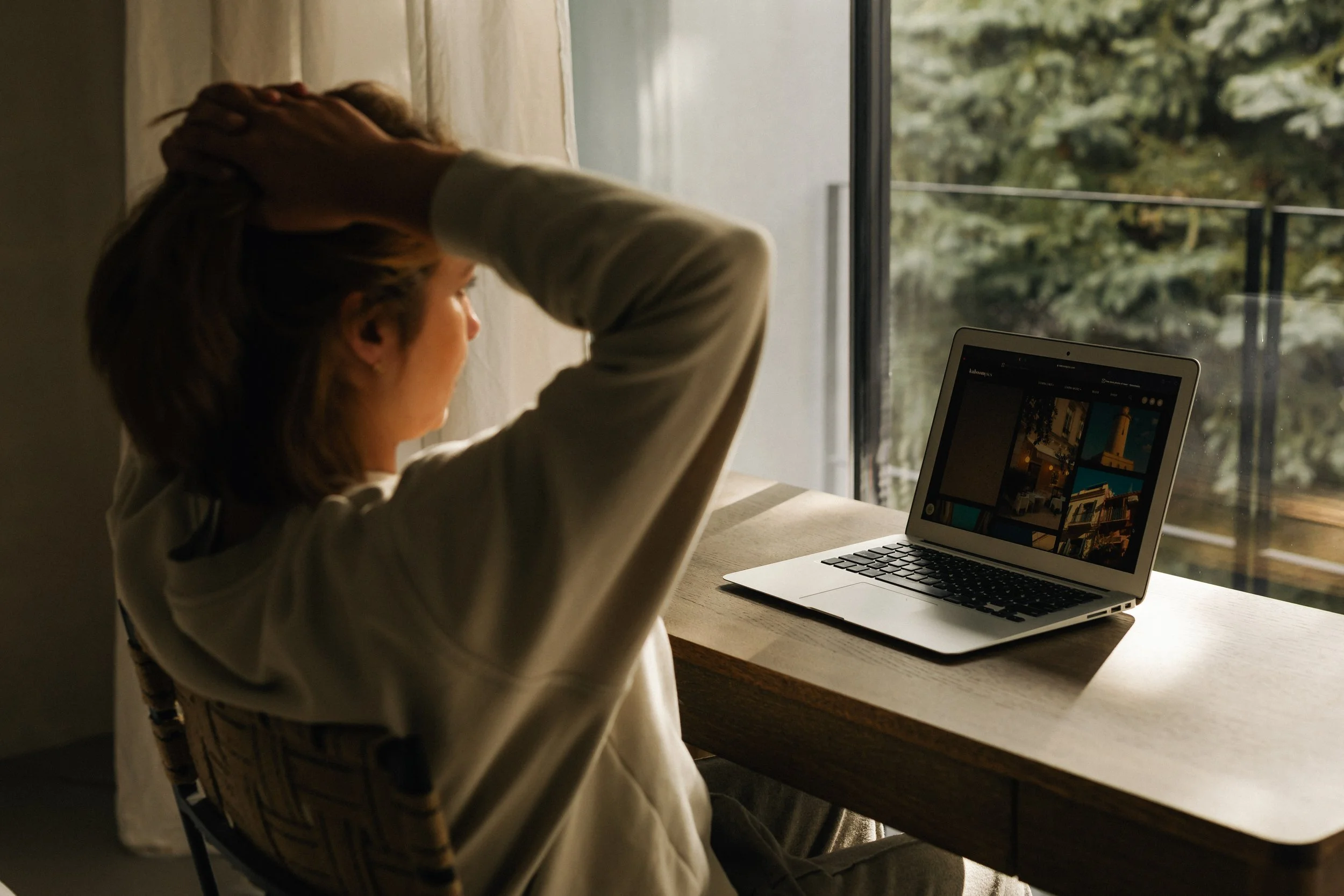 A professional feeling overwhelmed while working at a laptop.