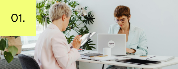 Two co-workers working together during a one-on-one workplace discussion.