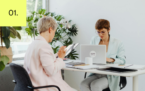 Two co-workers working together during a one-on-one workplace discussion.