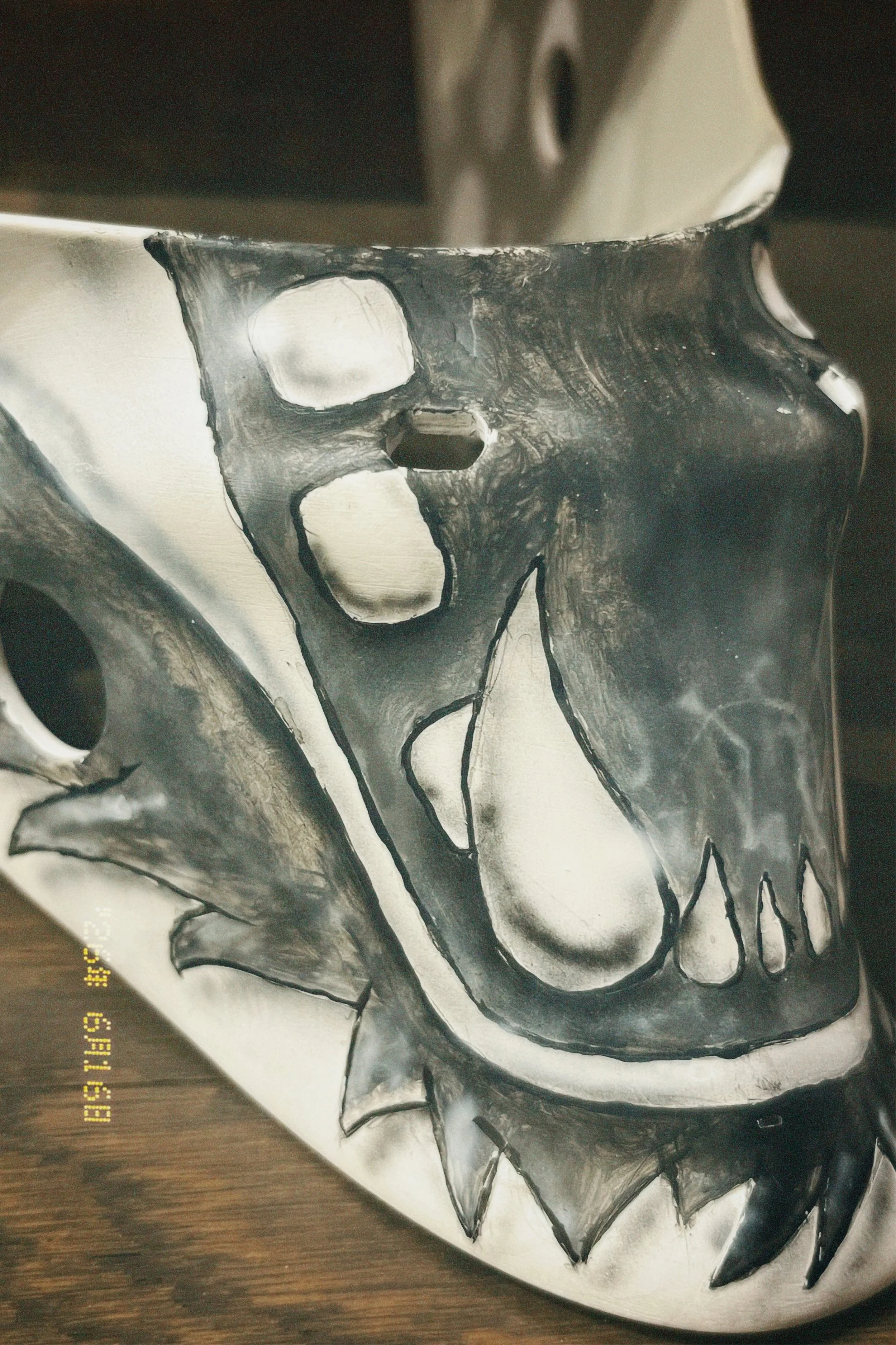 A skull painted with black and white spray paint on a piece of paper or canvas.