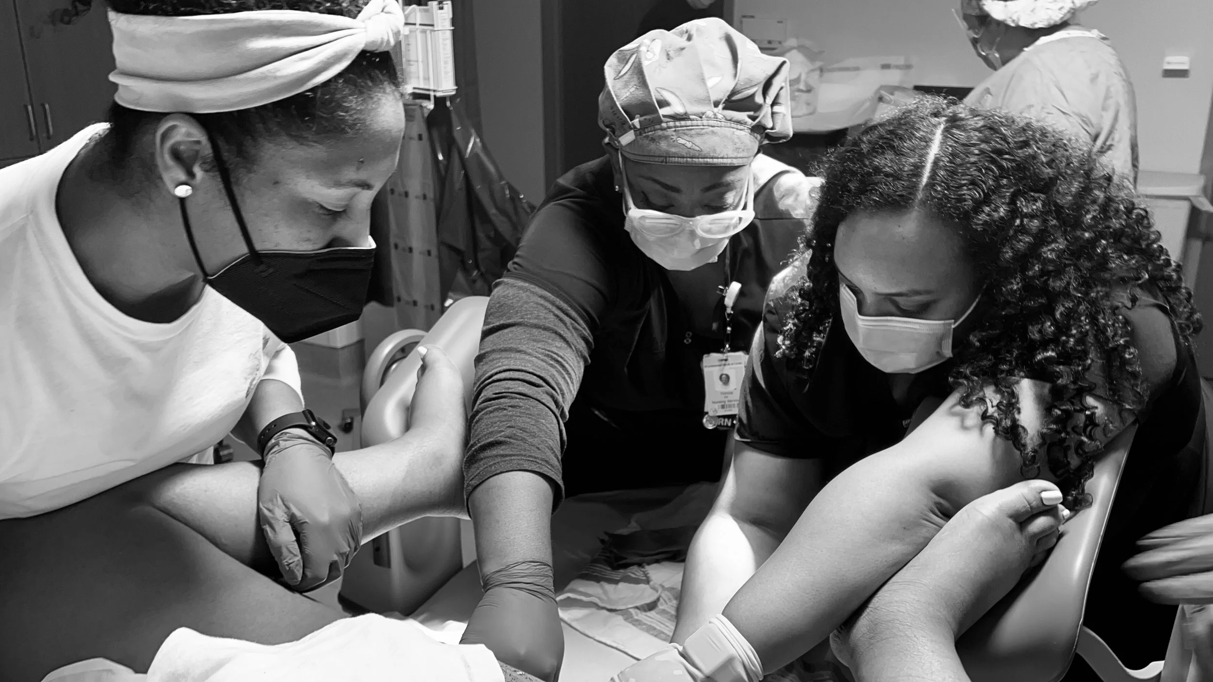 Medical professionals wearing masks and gloves assisting a patient during a blood donation or medical procedure in a clinical setting.