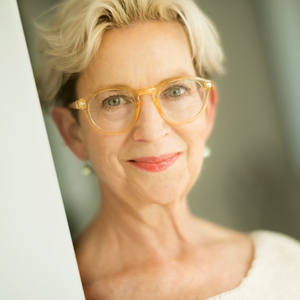 portrait photo of roxanne darling, wearing yellow-rimmed glasses