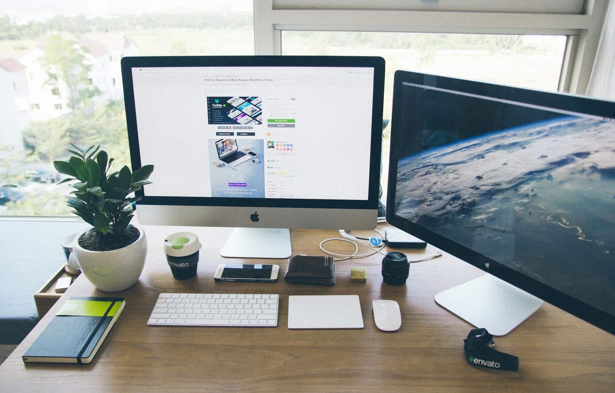 workspace with dual apple monitors, keyboard,
