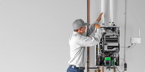 Technician repairing or inspecting a mechanical or electrical panel on a wall.