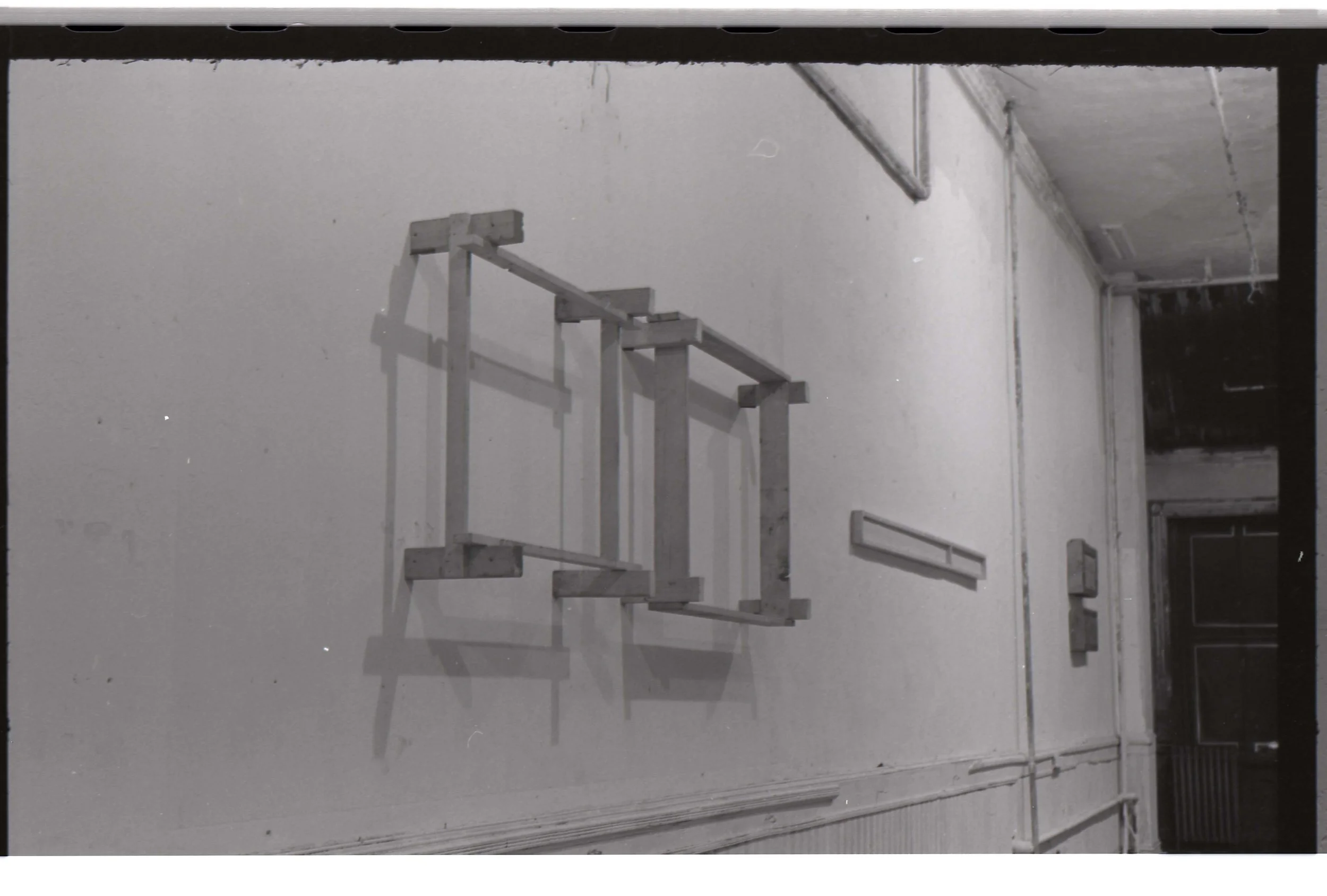 A black-and-white photo of a staircase with separate railings against a plain wall.