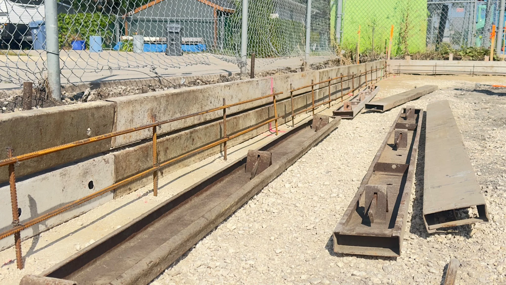 Concrete foundation preparation with metal railings and gravel base at Winnipeg construction site