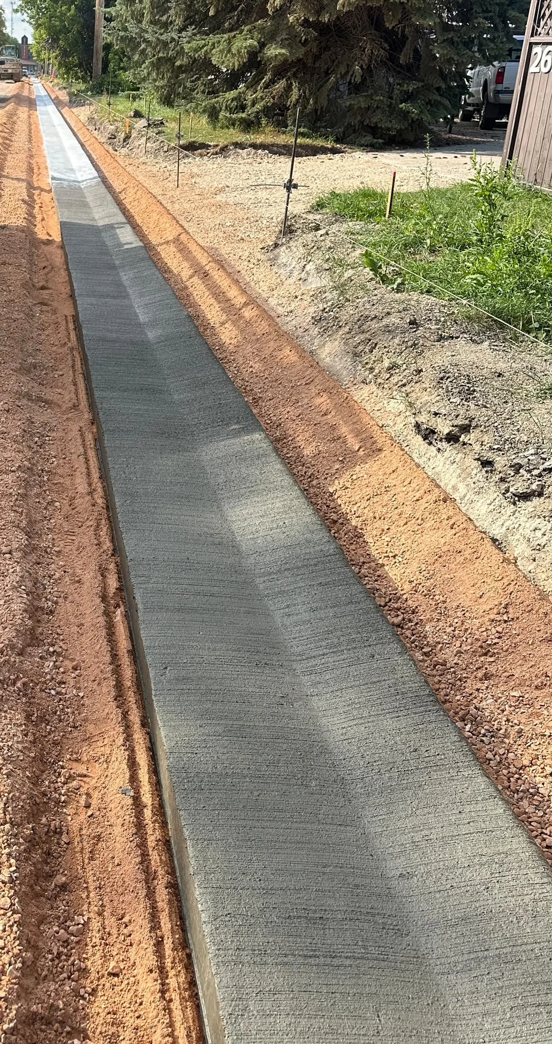 Freshly poured concrete curb and gather on a construction site, work by TSNA Construction Group In Winnipeg Manitoba.