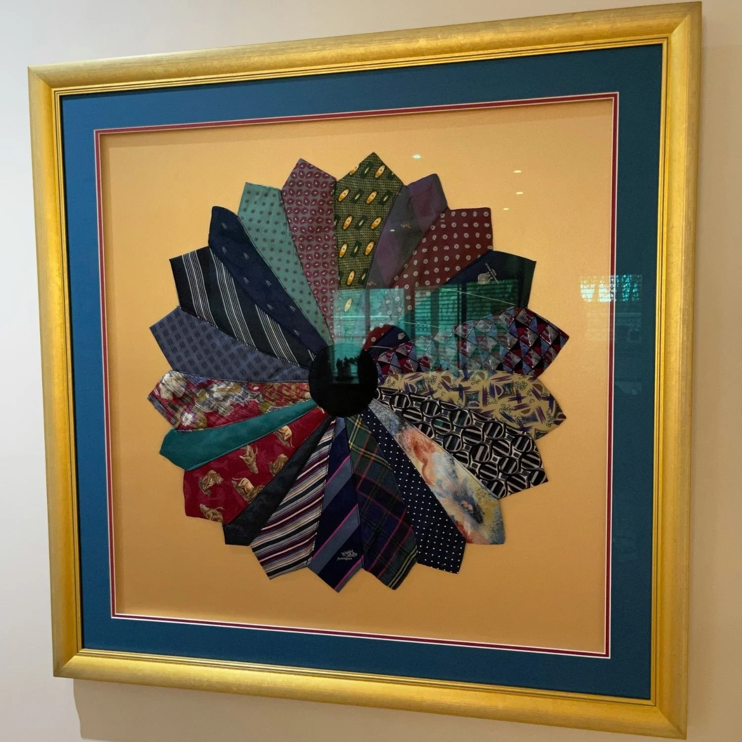 Necktie collection fan display in a gold frame, double mat