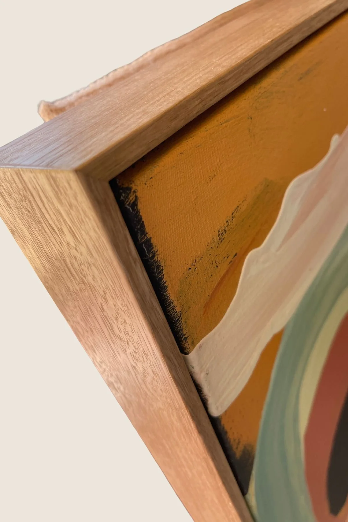 Float frame detail — abstract circle painting, natural oak