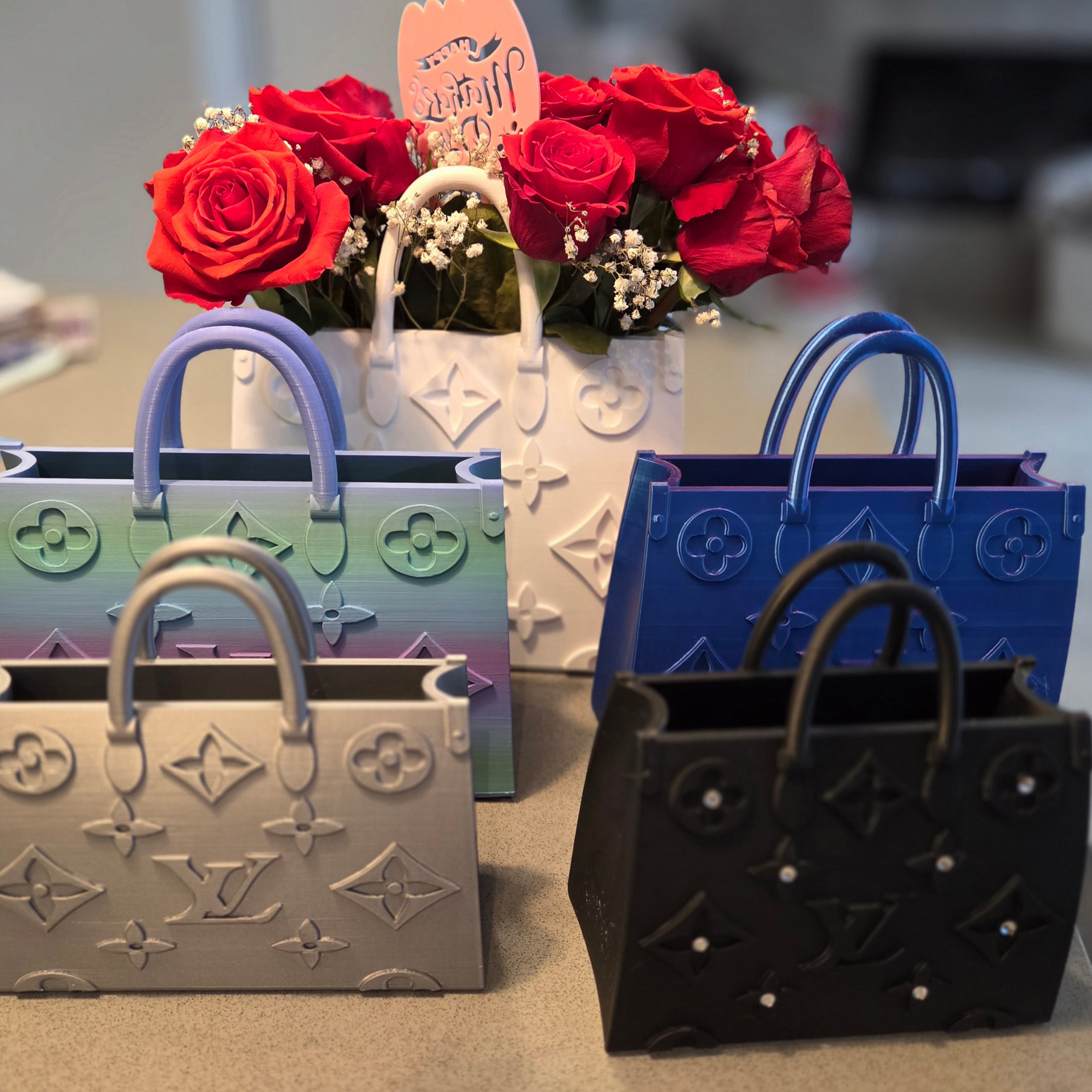Colorful tote bags made from designer brand Louis Vuitton's signature embossed monogram leather, displayed on a flat surface.