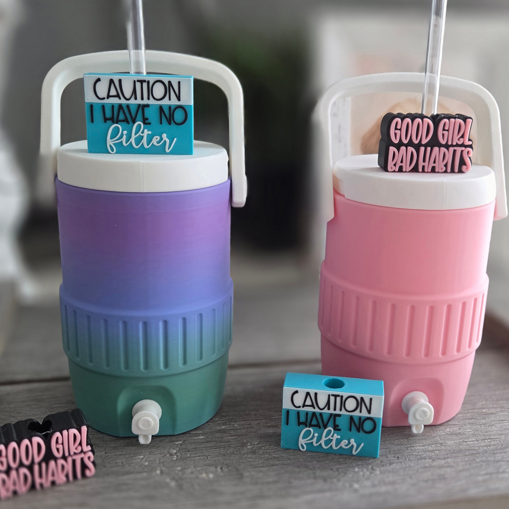 Colorful plastic toy shopping carts with caution signs saying 'Caution I have no filter' and 'Good girl bad habits' placed on a wooden surface.