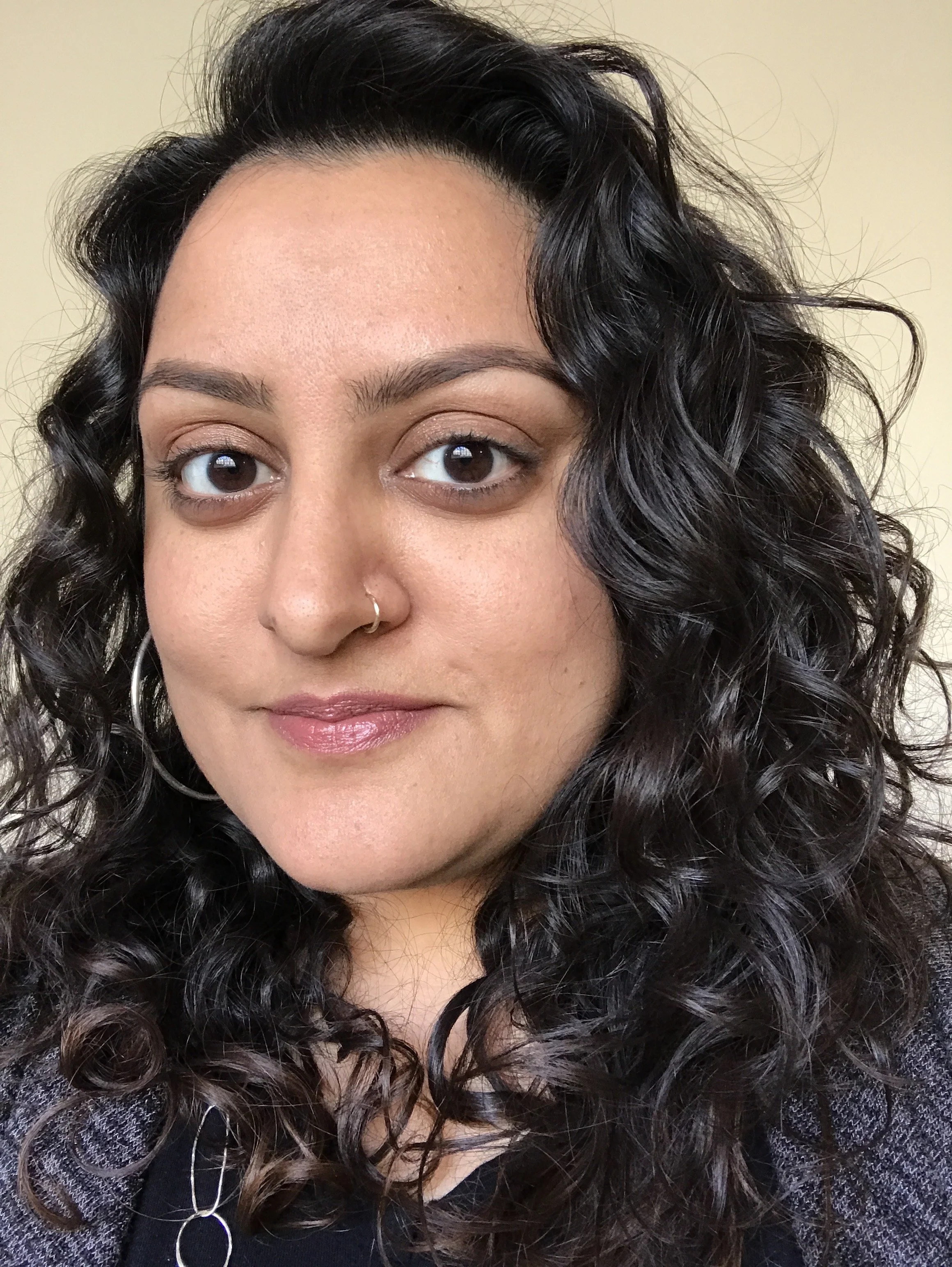 Close Up of Mamta Dadlani, long curly hair, dark brown eyes, light brown skin, nose ring