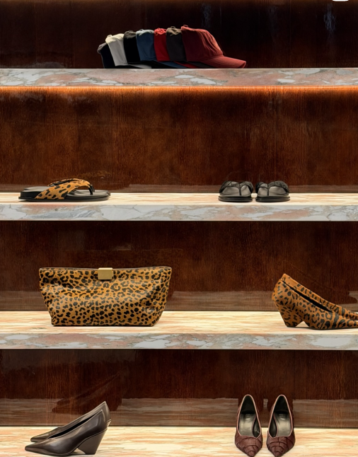 Display shelf with hats, shoes, and leopard print handbag and heels.