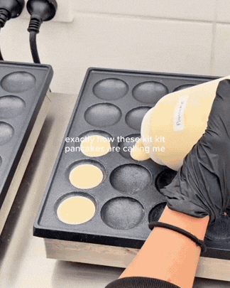 Person pouring pancake batter into a round mold on a black electric griddle.