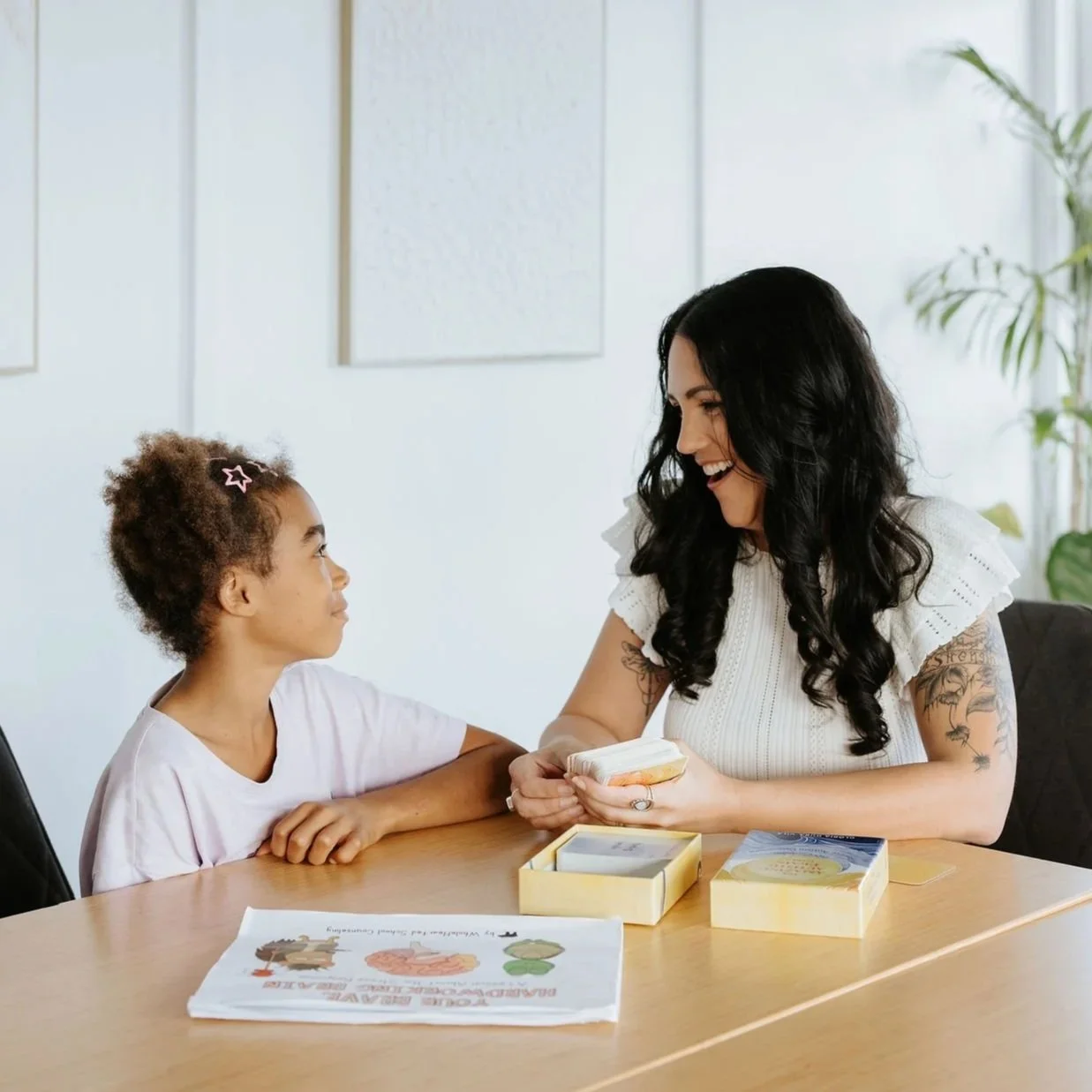 Candice Heffernan and a girl sitting at a table, working with cards to learn about personal strength.