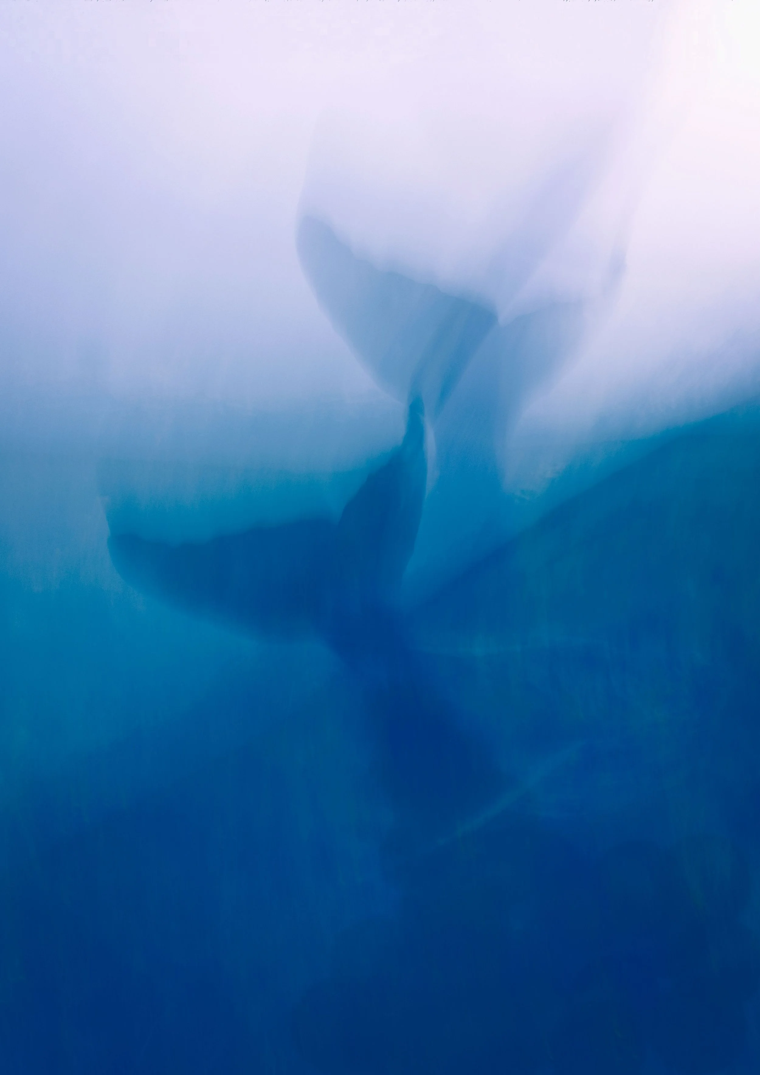 Close-up of ice, with a blurred background of glacier and sky.